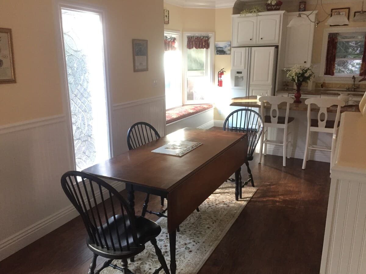 Dining table beside the kitchen and front windows