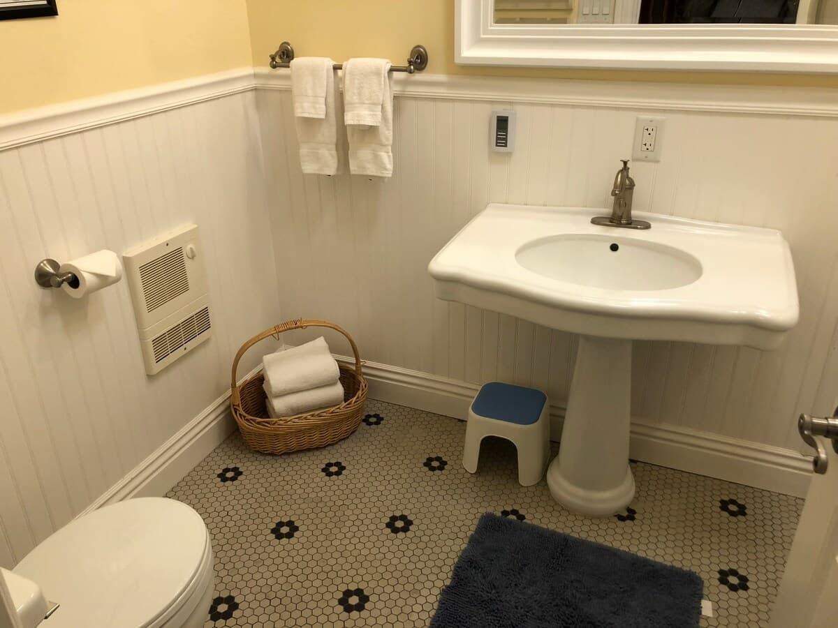 Second bathroom angle with pedestal sink and patterned floor tile